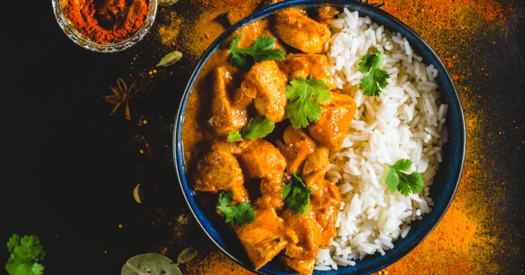 A vibrant bowl of rice recipe with Korean chicken, featuring tender chicken in a rich, spicy sauce, garnished with fresh cilantro and served alongside fluffy rice.
