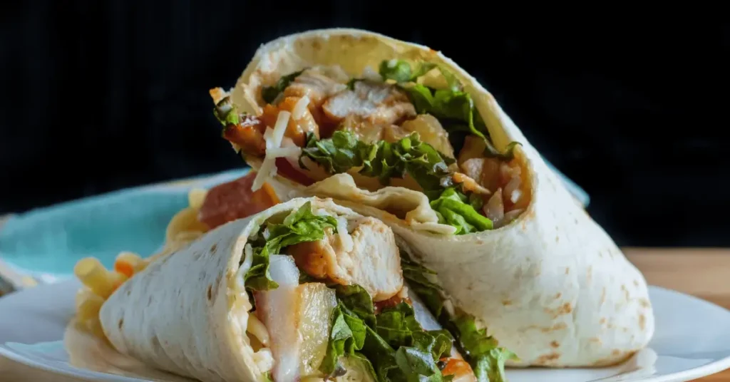 A delicious chicken salad wrap served with fresh greens and vegetables, showcasing a healthy chicken salad wrap recipe.